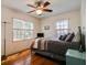 Cozy bedroom featuring hardwood floors, a modern ceiling fan, and two windows providing ample natural light at 1000 Pennsylvania Ave, Lakeland, FL 33803