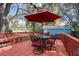 Outdoor deck area with a red umbrella, seating, and a view of the lush surroundings at 1000 Pennsylvania Ave, Lakeland, FL 33803