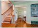 Inviting foyer with wood floors, open staircase, and doorway leading to dining room with built-in shelving at 1000 Pennsylvania Ave, Lakeland, FL 33803