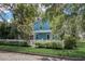 Exterior view of a charming blue two-story home with a white picket fence and covered porch at 1000 Pennsylvania Ave, Lakeland, FL 33803