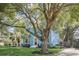Attractive blue two-story home featuring a well-maintained lawn and a mature tree adding character at 1000 Pennsylvania Ave, Lakeland, FL 33803