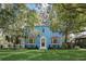 Charming blue two-story home with manicured lawn and beautiful mature trees creating curb appeal at 1000 Pennsylvania Ave, Lakeland, FL 33803