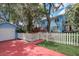 Quaint two-story blue home with detached garage, red driveway, and white picket fence at 1000 Pennsylvania Ave, Lakeland, FL 33803