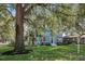 Inviting two-story blue home showcasing a lush lawn and mature trees providing ample shade at 1000 Pennsylvania Ave, Lakeland, FL 33803