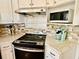 A modern kitchen is equipped with stainless steel appliances, stylish countertops, and a mosaic backsplash at 1000 Pennsylvania Ave, Lakeland, FL 33803