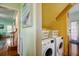Efficient laundry area featuring a modern washer and dryer, complemented by storage baskets for seamless organization at 1000 Pennsylvania Ave, Lakeland, FL 33803