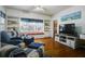A bright living room offers hardwood floors, custom built-ins, many windows, and two stylish accent chairs at 1000 Pennsylvania Ave, Lakeland, FL 33803