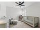 Bedroom/bedroom with neutral colors, a ceiling fan, shuttered windows, and a crib at 1129 Golfside Dr, Winter Park, FL 32792