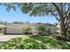 Charming home featuring mature trees, green lawn, and a welcoming front entrance with a pergola at 1129 Golfside Dr, Winter Park, FL 32792