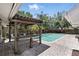 Backyard pool with brick paver patio, bar and lush tropical landscaping offering a private outdoor retreat at 1129 Golfside Dr, Winter Park, FL 32792