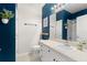 Well-lit bathroom with white vanity, blue accent wall, and neutral tile flooring at 12936 Freeman St, Windermere, FL 34786