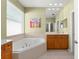 Bright bathroom with garden tub, light green walls, and mirrored vanity at 12936 Freeman St, Windermere, FL 34786
