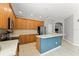 Open-concept kitchen with oak cabinetry, stainless steel appliances, and a breakfast bar for casual dining at 12936 Freeman St, Windermere, FL 34786