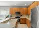 Well-lit kitchen features oak cabinets, stainless steel appliances and stone countertops at 12936 Freeman St, Windermere, FL 34786