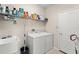 Well-organized laundry room featuring modern washer, dryer, sink, and ample shelving for storage at 12936 Freeman St, Windermere, FL 34786