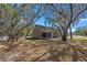 A spacious backyard with mature trees and a screened in back porch create a serene outdoor setting at 130 Kristi Ann Ct, Winter Springs, FL 32708