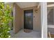 Inviting front entry featuring a black screen door, exterior lighting, and lush flowering bushes at 130 Kristi Ann Ct, Winter Springs, FL 32708
