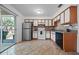 Well-lit kitchen with tile flooring, white cabinets, stainless steel fridge, and black appliances at 130 Kristi Ann Ct, Winter Springs, FL 32708