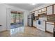 Well-lit kitchen featuring tile floors, white cabinets, a stainless steel fridge, and access to the lanai at 130 Kristi Ann Ct, Winter Springs, FL 32708