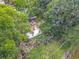An aerial view of an overgrown lot with sheds and detritus obscured by trees at 1314 S Mellonville Ave, Sanford, FL 32771