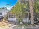 Exterior view of a home with a screened porch surrounded by overgrown landscaping at 1314 S Mellonville Ave, Sanford, FL 32771