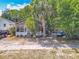 Exterior shot of property with overgrown landscaping and a screened front porch at 1314 S Mellonville Ave, Sanford, FL 32771
