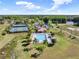 Aerial view of the community pool and tennis courts, surrounded by trees and a river at 14315 Letham Grange Ct, Orlando, FL 32828