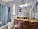 This bathroom has blue walls, a large mirror, and a shower behind a blue curtain at 14315 Letham Grange Ct, Orlando, FL 32828
