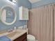 This bathroom has blue walls, a vanity, and a shower behind a taupe colored curtain at 14315 Letham Grange Ct, Orlando, FL 32828