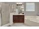 Bright bathroom features a walk-in shower, soaking tub, and wood vanity at 14315 Letham Grange Ct, Orlando, FL 32828
