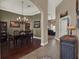 Dining room featuring a tray ceiling, chandelier, wood floors, and views into the living room at 14315 Letham Grange Ct, Orlando, FL 32828