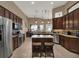 Large kitchen featuring an island, stainless steel appliances, granite countertops, and dark wood cabinetry at 14315 Letham Grange Ct, Orlando, FL 32828