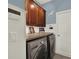 Modern laundry room with front-load washer and dryer, ample counter space, and storage cabinets at 14315 Letham Grange Ct, Orlando, FL 32828