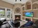 Gathering room featuring fireplace, custom built-ins, and views of the outdoor pool area at 14315 Letham Grange Ct, Orlando, FL 32828