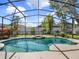 Relax in this sparkling pool with a screened-in enclosure and lush landscaping at 14315 Letham Grange Ct, Orlando, FL 32828
