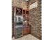 Elegant wine bar featuring a stone wall, wine fridge, and wood cabinetry for storage at 14315 Letham Grange Ct, Orlando, FL 32828