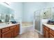 This bathroom features a large soaking tub, tiled floors, and and sinks at 1457 Waukon Cir, Casselberry, FL 32707