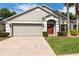 Charming single-story home featuring a brick driveway, well-kept lawn, and attached two-car garage at 1457 Waukon Cir, Casselberry, FL 32707