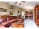 Cozy living room with a leather sectional, a decorative archway, and a built-in bookcase at 1457 Waukon Cir, Casselberry, FL 32707