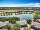 An aerial view showcases lakeside condos with lush trees, water view, and easy access to the highway at 163 Villa Di Este Ter # 105, Lake Mary, FL 32746