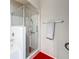 Bathroom features a glass shower with red flooring, and towel rack with towel at 163 Villa Di Este Ter # 105, Lake Mary, FL 32746