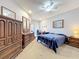 Bedroom featuring neutral carpet, ceiling fan, desk area, and wooden dresser at 163 Villa Di Este Ter # 105, Lake Mary, FL 32746