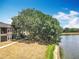 Waterfront property with lake views. Exterior with a large shade tree adjacent to water at 163 Villa Di Este Ter # 105, Lake Mary, FL 32746