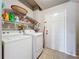 Functional laundry room featuring washer, dryer, wire shelving, and door to exterior at 163 Villa Di Este Ter # 105, Lake Mary, FL 32746