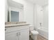 Bright bathroom featuring granite counters, white cabinets, and a shower over tub at 16391 Bird Of Paradise Ave, Clermont, FL 34714