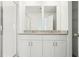 Bathroom featuring dual vanities with granite countertops, bright lighting, and walk-in shower at 16391 Bird Of Paradise Ave, Clermont, FL 34714