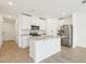 Well-lit kitchen boasting white cabinetry, stainless steel appliances, and a functional island with granite countertops at 16391 Bird Of Paradise Ave, Clermont, FL 34714