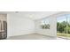 Bright living room with large window views of the lush green backyard at 16391 Bird Of Paradise Ave, Clermont, FL 34714