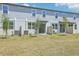 A well-maintained backyard featuring sliding glass doors and a lush green lawn in a residential townhouse at 16399 Bird Of Paradise Ave, Clermont, FL 34714