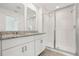 Bathroom featuring double sinks, granite countertops, and a sleek glass-enclosed shower at 16399 Bird Of Paradise Ave, Clermont, FL 34714